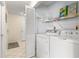 Convenient laundry area with washer, dryer, and shelving for storage, neatly tucked away in a utility closet at 6131 Bahia Del Mar Blvd # 241, St Petersburg, FL 33715