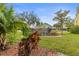 Serene backyard featuring lush greenery, a charming wooden bridge, and partial view of the condo complex at 6319 Sunset Bay Cir, Apollo Beach, FL 33572