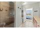Bright bathroom featuring a glass-enclosed shower and separate soaking tub, next to the primary bedroom at 6319 Sunset Bay Cir, Apollo Beach, FL 33572