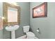 Charming powder room with a pedestal sink, decorative mirror, and classic fixtures at 6319 Sunset Bay Cir, Apollo Beach, FL 33572