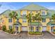 Lovely yellow townhomes with green roofs, garages, and charming front door decorations at 6319 Sunset Bay Cir, Apollo Beach, FL 33572