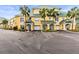 Inviting yellow condo complex with vibrant landscaping, palm trees, and private garages in a desirable neighborhood at 6319 Sunset Bay Cir, Apollo Beach, FL 33572