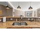 Kitchen with granite countertops, a stainless steel sink, tile backsplash, and stylish pendant lighting at 6319 Sunset Bay Cir, Apollo Beach, FL 33572
