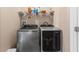 Modern laundry room features stainless steel front-loading washer and dryer, plus overhead storage shelf at 6319 Sunset Bay Cir, Apollo Beach, FL 33572
