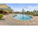 Inviting pool area with a green building, lush landscaping, and ample deck space at 6319 Sunset Bay Cir, Apollo Beach, FL 33572
