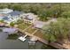 Aerial view of neighborhood property showing a backyard canal, boat lift, trees, and neighboring homes at 6914 Harbor Dr, Hudson, FL 34667