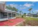 Backyard view featuring a screened lanai, brick patio, and canal frontage with a private dock at 6914 Harbor Dr, Hudson, FL 34667