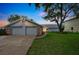 Charming home featuring a well-manicured lawn, stone accents, and a spacious two-car garage at 6914 Harbor Dr, Hudson, FL 34667