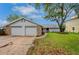 Front exterior view of home with a two-car garage, stone accents, and a well-manicured lawn at 6914 Harbor Dr, Hudson, FL 34667