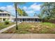 Home featuring a long screened porch and water views surrounded by a partially landscaped yard at 6914 Harbor Dr, Hudson, FL 34667