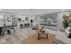 Bright open-concept living space featuring wood-look floors and access to a screened porch at 6914 Harbor Dr, Hudson, FL 34667