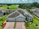 Aerial view of this well maintained home with a three-car garage and beautiful landscaping in a golf community at 724 Chipper Dr, Sun City Center, FL 33573
