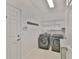 This spacious laundry room features modern washer and dryer units, shelving, and a convenient coat rack at 724 Chipper Dr, Sun City Center, FL 33573
