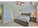 The main bedroom features a wood bed frame, ceiling fan, and an adjacent bathroom at 724 Chipper Dr, Sun City Center, FL 33573