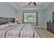 The main bedroom features a wood bed frame, ceiling fan, a view to nature, and a dresser at 724 Chipper Dr, Sun City Center, FL 33573