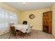 An inviting dining room with a round table, upholstered chairs, a window with sheer curtains, and a dark wooden cabinet at 7317 W Pocahontas Ave, Tampa, FL 33634