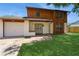 View of the home's exterior with a well-manicured lawn and a driveway leading to the attached garage at 7317 W Pocahontas Ave, Tampa, FL 33634