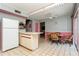 Eat-in kitchen area with tiled floors, ample counter space, white appliances, and a staircase leading to the upper level at 7317 W Pocahontas Ave, Tampa, FL 33634