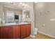 Bright bathroom with double sinks, cherry wood cabinets, and tile flooring at 7518 Tangle Brook Blvd, Gibsonton, FL 33534