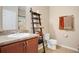 Charming bathroom featuring a vanity with granite countertop, ladder shelf, and tiled floor at 7518 Tangle Brook Blvd, Gibsonton, FL 33534