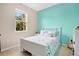 Cozy bedroom with a single bed, soft blue and white decor, and natural light at 7518 Tangle Brook Blvd, Gibsonton, FL 33534