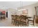 Open-concept dining area features a large wooden table with seating for six and modern lighting at 7518 Tangle Brook Blvd, Gibsonton, FL 33534