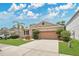 Inviting single-story home with a manicured front lawn, a two-car garage, and a palm tree at 7518 Tangle Brook Blvd, Gibsonton, FL 33534