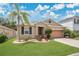 Beautiful single-story home with manicured lawn, lush landscaping, and an attached two-car garage at 7518 Tangle Brook Blvd, Gibsonton, FL 33534