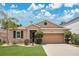 Charming single-story home featuring a well-manicured lawn, mature landscaping, and an attached two-car garage at 7518 Tangle Brook Blvd, Gibsonton, FL 33534