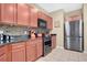 Modern kitchen with stainless steel appliances, dark countertops, and wood cabinets at 7518 Tangle Brook Blvd, Gibsonton, FL 33534