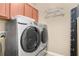 Modern laundry room equipped with front load washer and dryer, complemented by overhead cabinets at 7518 Tangle Brook Blvd, Gibsonton, FL 33534