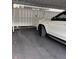 Angle view of white SUV parked in carport, next to white, tall, wooden privacy fence and concrete floor at 7605 W Deleon Ct, Tampa, FL 33615