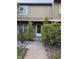 Inviting front entrance to this townhome with manicured landscaping and walkway at 7605 W Deleon Ct, Tampa, FL 33615