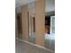 View of living room with tiled flooring, mirrored wall and pass through to kitchen at 7605 W Deleon Ct, Tampa, FL 33615