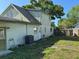 Back of the house view shows the AC unit, door, side yard, and a portion of the roof at 8244 125Th St, Seminole, FL 33772