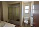 Bathroom featuring a tub with glass doors, a toilet, and a window at 8244 125Th St, Seminole, FL 33772