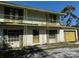 Two-story brick home featuring a wrought iron balcony, shutters, and a yellow garage door at 8244 125Th St, Seminole, FL 33772
