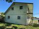 View of the side of the home featuring a wrought iron balcony and two windows at 8244 125Th St, Seminole, FL 33772