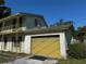 View of a brick garage attached to the two-story home featuring a yellow door at 8244 125Th St, Seminole, FL 33772