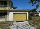 View of the attached yellow brick garage with a driveway at 8244 125Th St, Seminole, FL 33772