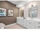 Elegant bathroom featuring double vanity with white cabinets and modern rectangular mirrors at 8913 Bernini Pl, Sarasota, FL 34240