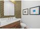 Modern powder room with a decorative mirror, stylish vanity, and elegant finishes at 8913 Bernini Pl, Sarasota, FL 34240