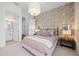 Comfortable bedroom with floral wallpaper, a plush bed, and access to bathroom at 8913 Bernini Pl, Sarasota, FL 34240