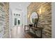 Welcoming foyer with stone accent wall, wood floors, and contemporary decor at 8913 Bernini Pl, Sarasota, FL 34240
