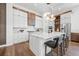 Open kitchen with white cabinets, marble countertops, stainless steel appliances, and a center island with seating at 8913 Bernini Pl, Sarasota, FL 34240