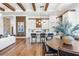 Open-concept kitchen features an island with seating, hardwood floors, and decorative wood beam ceilings at 8913 Bernini Pl, Sarasota, FL 34240