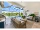 Lovely lanai with an outdoor kitchen and plush seating overlooking the pool and water views at 8913 Bernini Pl, Sarasota, FL 34240
