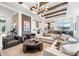 Stunning living room with stone accent walls, wood beams, and an open-concept kitchen and dining area at 8913 Bernini Pl, Sarasota, FL 34240