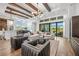 Open-concept living room with wood floors, modern decor, and a view of the pool at 8913 Bernini Pl, Sarasota, FL 34240