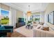 Bright living room with large windows, a comfortable sofa, modern furnishings, and scenic views at 8913 Bernini Pl, Sarasota, FL 34240
